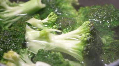 Taze brokoli, sobanın üstündeki mutfak demliğinde yavaşça pişiyor..