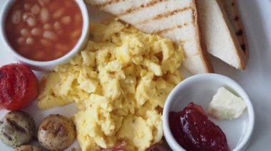 Yağda yumurta, tost ve fırında fasulye içeren doyurucu bir kahvaltının tadını çıkar..