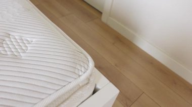 Konforlu bir yatak odası, lüks bir yatak ve sıcak ahşap döşemeler sergiler..