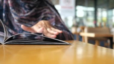 Konforlu bir kafe ortamında bir menüyü araştırmak,