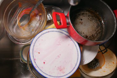 Büyük bir aile yemeğinden sonra başıboş tencere ve tabaklar lavaboya yığılır..