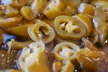 Keskin sirkeye batırılmış dilimlenmiş yeşil jalapenolar. Isı eklemek için ideal..