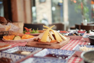 Meyve ve ve ekmeklerle zarif bir şekilde sergilenen gurme peynir tabağı..