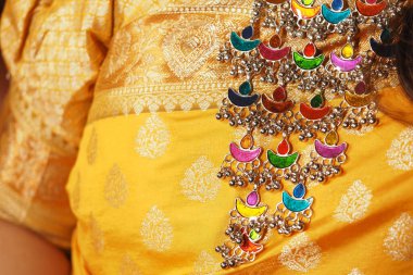 Neşeli mücevherler, şenlikli bir günde altın bir elbiseyi tamamlar..