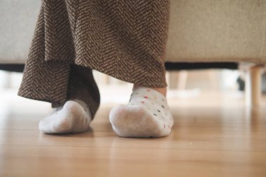 Kişi, güneşli bir günde renkli çoraplarıyla desenli pantolonla rahatlar..