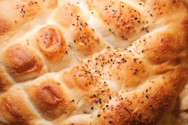 Altın kahverengi kabuklu lezzetli ekmek ve serpiştirilmiş tohumlar..