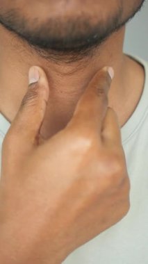 Rahatsızlık ya da ağrı kontrolü yaparken boğazına dokunan biri..