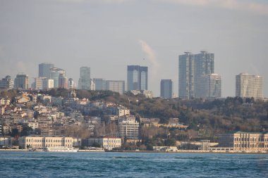 Şehir manzarası huzurlu suların üzerinde yükselen yüksek binaları gösteriyor..
