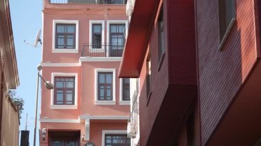 Parlak boyanmış binalar canlı bir bölgede, berrak bir gökyüzünün altında dimdik duruyorlar..