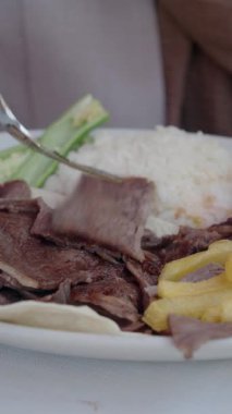 Et, patates kızartması ve pirinçli lezzetli bir yemeğin yakın çekimi..