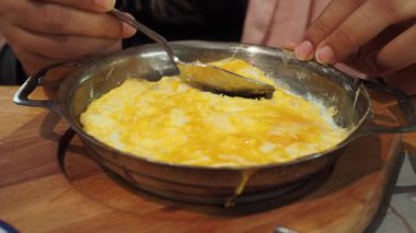 Sıcak bir yemek masasında erimiş peynirle lezzetli bir yemeğin tadını çıkarıyorum..