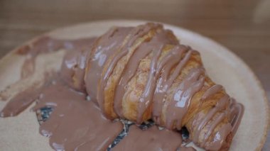 Zengin çikolata soslu taze pişmiş kruvasan servis edilir..