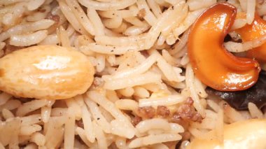 Pirinç, baharat ve karışık fındıklı lezzetli bir biryani yemeği sunuluyor..