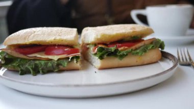 Lezzetli bir sandviç taze malzemelerle hazırlanır, kahveyle servis edilir..