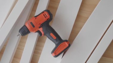 Ev yenilenmesinde ahşap şerit montajı için kablosuz matkap kullanılıyor.
