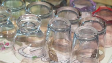 Değişik tasarlanmış cam bardaklar canlı bir pazarda sergileniyor..