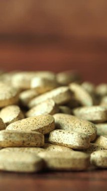 Tahta bir yüzey üzerinde farklı tür doğal katkı tabletleri sergilenir.