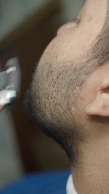 Bir berber, sabah bir berber dükkanında adamın sakalını ustalıkla şekillendirir..