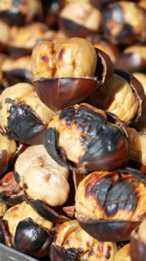 İnsanlar canlı bir sonbahar etkinliğinde kavrulmuş kestane sever..