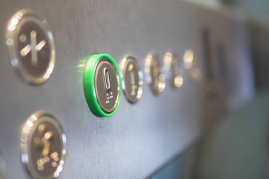 Asansör kontrol panelinin bir binada yanan bir düğmesi var..