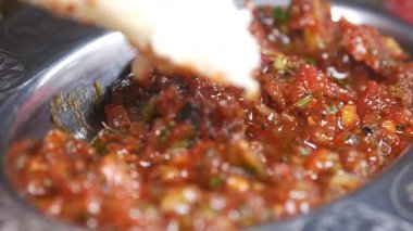 Meşgul bir lokantada baharatlı kırmızı sosa ekmek batırmak..