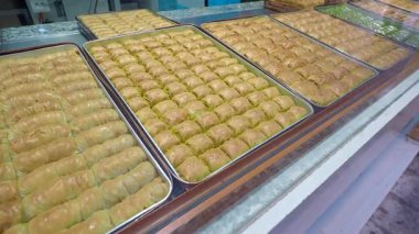 Sıralar dolusu taze baklava müşterileri şeker dükkanında bekliyor.
