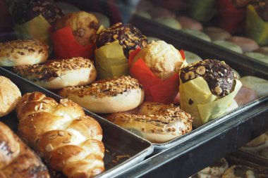 Lezzetli hamur işlerinin çeşitliliği düzenli olarak düzenlenir, müşteriler içeri girerler..