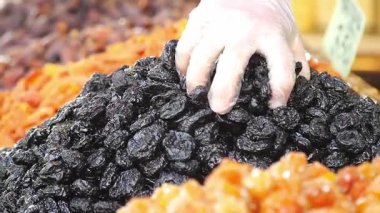 Bir el rengarenk meyvelerden kurutulmuş kuru erik seçer.