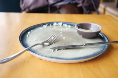 Tabakta kalan pirinç taneleri ve yakında duran çatal bıçaklar..