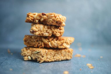 Lezzetli granola barları mavi yüzeyde kırıntılarla sıralanmış..