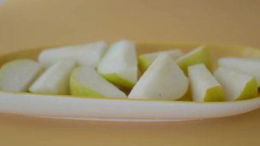 Lezzetli armut dilimleri atıştırmak için bir tabakta güzelce düzenlenir..