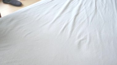 Hoş geldin yatak odasında bir insan temiz çarşaf serer..