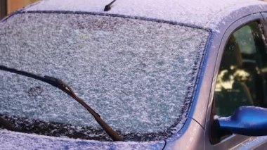 Soğuk bir kış gününde, taze karla kaplı bir arabanın ön camı..
