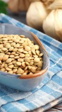 Kurutulmuş mercimek, damalı kumaş üzerinde kırsal bir kasede..