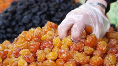 Bir el renkli bir pazardan parlak kurumuş meyveler seçer.