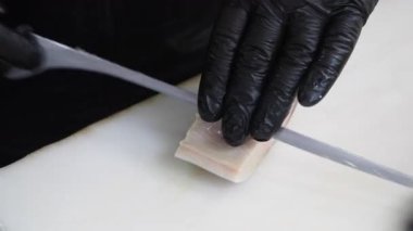 Şef, aşçılık atölyesinde ustalıkla taze balık kesiyor..