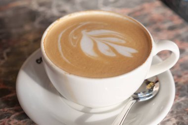 Sıcak bir kafe ortamında köpük sanatıyla sıcak bir lattenin tadını çıkar..