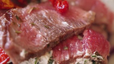 Yumuşak biftek dilimleri canlı renkler ve bitkilerle dolu dokular gösterir..