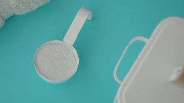 Bir insan, açık mavi bir yüzey üzerinde karıştırma araçlarıyla pişirme malzemeleri hazırlar..