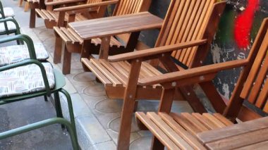 Açık havada misafirler için ayarlanmış ahşap sandalyeler var..