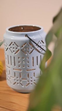 Detaylı tasarımları olan açık mavi bir fener masanın üzerinde büyüleyici bir şekilde durur..