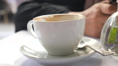 Kafe atmosferinde dinlenirken sıcak bir fincan kahve içiyorum..