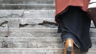 Şehrin tarihi mimarisi ile kaplanmış yıpranmış basamaklarda yürüyen bir kişi var..