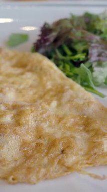 Yanında canlı bir salata ve olgun domatesli tuzlu omlet..