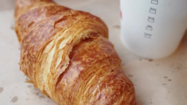 Lezzetli bir kruvasan fırında sıcak bir fincan kahvenin yanında dinlenir..