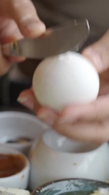 Birisi ev mutfağında ustalıkla beyaz yumurta kesiyor..