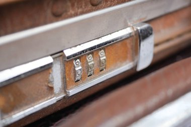 Yakın plan çekimde eski bir valiz kilidinde soluk numaralar görülüyor..