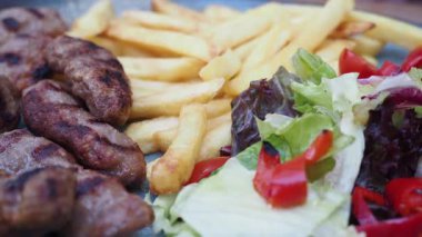 Kızarmış et, kızarmış patates ve taze salatanın tadını çıkarın..