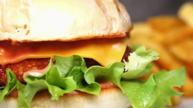 Taze sebzeli ve kızarmış patatesli peynirli burgerin tadını çıkar..