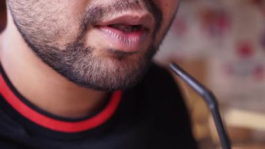 Kafede içkisini yudumlayan bir adam arkadaşlarıyla vakit geçirmekten zevk alır..